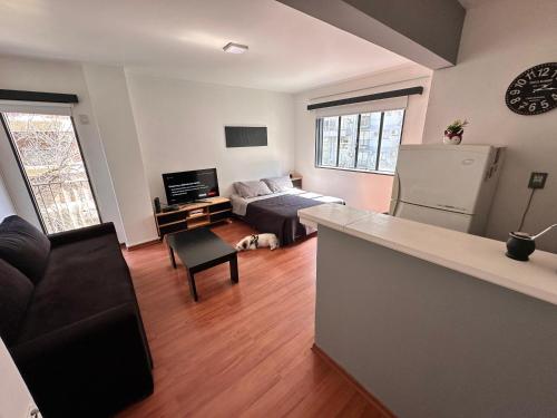 - un salon avec un canapé et un réfrigérateur dans l'établissement Apartamento en Las Cañitas, à Buenos Aires