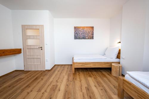 a room with white walls and a bed and a door at Wellness zoo apartmány Lhota in Lomnice nad Lužnicí