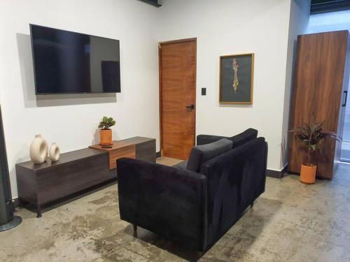 a living room with two couches and a flat screen tv at Loft cobre en excelente ubicación in San Luis Potosí