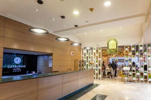 a lobby of a store with a counter and people at Hotel Catalinas Tucuman in San Miguel de Tucumán