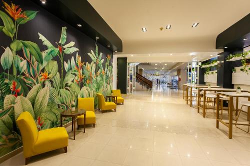 a restaurant with a large mural of plants on the wall at Hotel Catalinas Tucuman in San Miguel de Tucumán