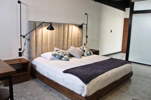a bedroom with a large bed with a wooden headboard at Loft cobalto en excelente ubicación! in San Luis Potosí