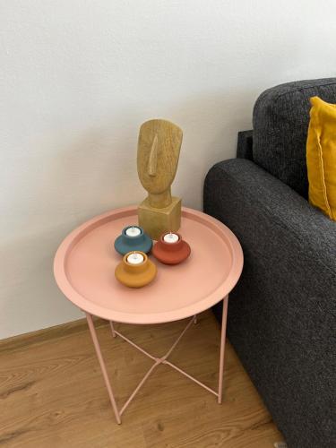 a pink table with donuts on it next to a couch at Apartman G6 in Bjelovar