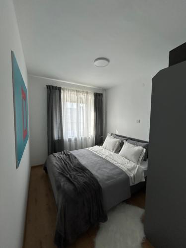 um quarto com uma cama grande com lençóis brancos e almofadas em Apartman G6 em Bjelovar