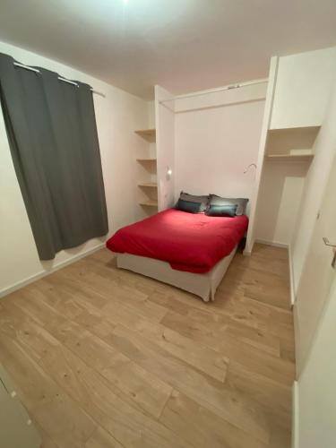 a bedroom with a bed with a red blanket at Gîtes du Moulin de Périssé in Fleurance