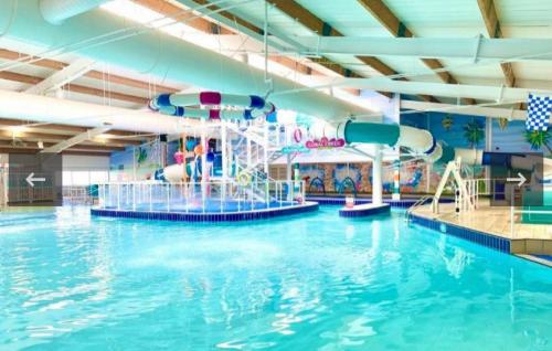 a large indoor swimming pool with a water slide at LillyPad Caravan in Selsey