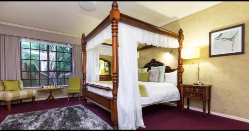 una grande camera da letto con letto a baldacchino e finestra di Mahogany Inn and Distillery a Mahogany Creek