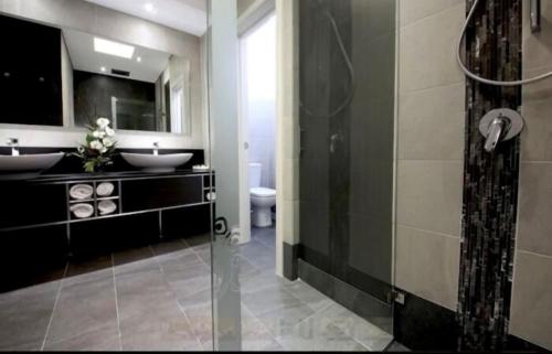 a bathroom with two sinks and a glass shower at Mahogany Inn and Distillery in Mahogany Creek