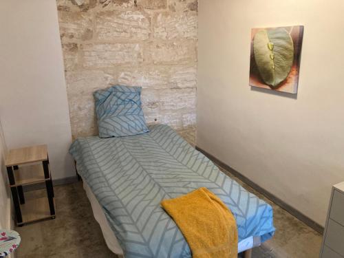 um quarto com uma cama e um quadro na parede em Maison au cœur de la Ville. em Saint-Gilles