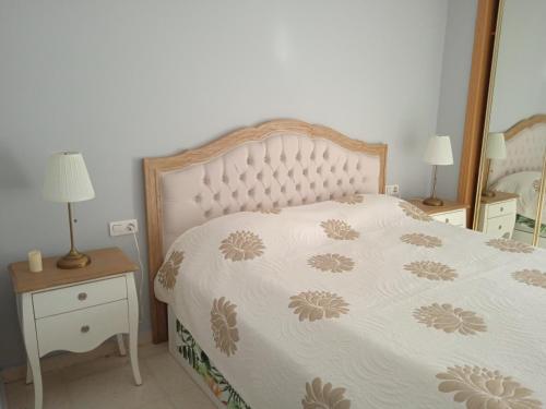 a bedroom with a bed with a white comforter at ALQUILO Habitación doble baño privado in Torremolinos