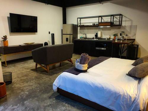 a bedroom with a large bed and a kitchen at Loft Bronce en excelente ubicación! in San Luis Potosí