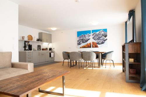 a living room with a table and a kitchen at Gutshof Alpenblick am Simssee - über den man spricht in Stephanskirchen