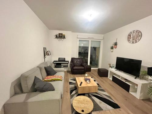 uma sala de estar com um sofá e uma mesa em Le cocon marnais - appart 2P em Villiers-sur-Marne