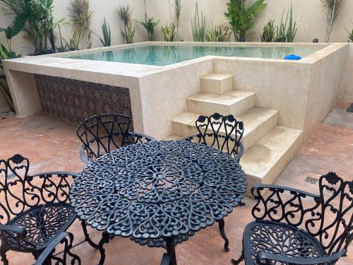 a patio with a table and chairs and a swimming pool at Casa del artista in Mérida