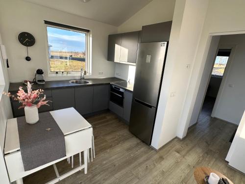 a kitchen with a black refrigerator and a table at Farmer's Guest House in Hella