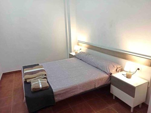 a bedroom with a bed and a nightstand with two lamps at Vivienda Planta Baja in Algemesí