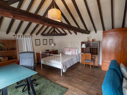 a bedroom with a bed and a desk and a table at Donde Conchita, buhardilla con baño compartido, cerca del aeropuerto norte in La Laguna