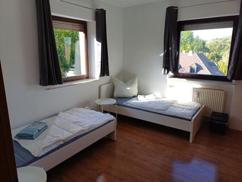 2 Betten in einem Zimmer mit 2 Fenstern in der Unterkunft L8 Street-Hösbach-Four Bed Rooms Flat in Hösbach