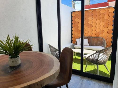 a table and chairs in a room with a table and a patio at Departamento con estilo y excelente ubicación in San Luis Potosí