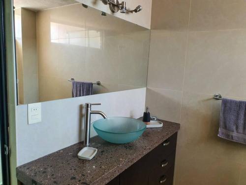 een badkamer met een blauwe wastafel op een aanrecht bij Departamento con estilo y excelente ubicación in San Luis Potosí