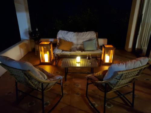 a patio with a couch and two chairs and lights at Casa de Encanto Tropical Villa in Playa Hermosa