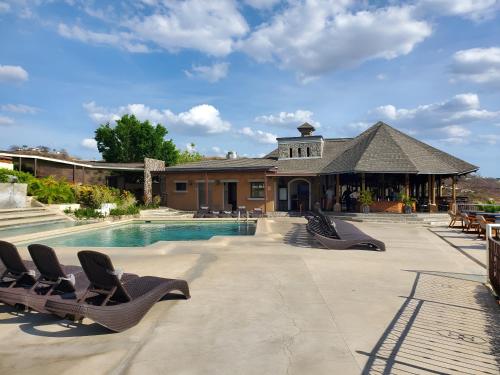 uma piscina com espreguiçadeiras em frente a uma casa em Casa de Encanto Tropical Villa em Playa Hermosa