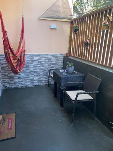 a patio with a table and chairs and a hammock at Katila-Rooms in Santa Maria