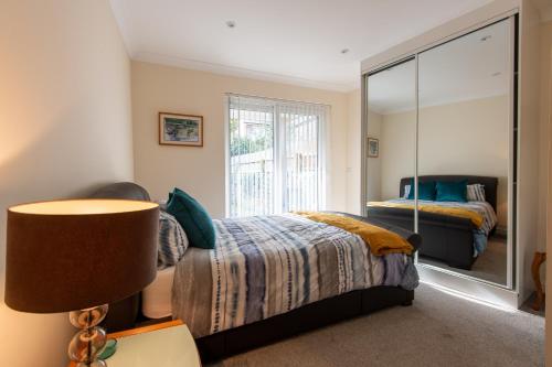 sypialnia z łóżkiem i dużym lustrem w obiekcie Seaview Cottage w Cardiff