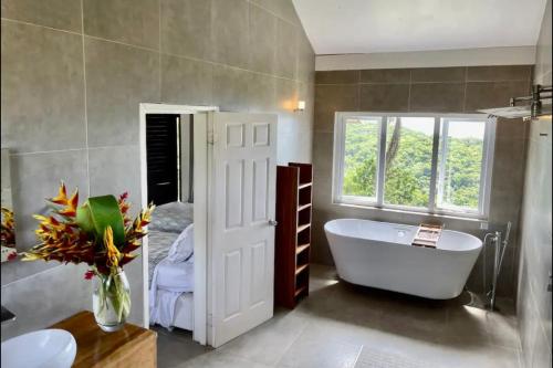 a bathroom with a tub and a bed and a window at Luxury villa located in Montego Bay, Jamaica in Montego Bay