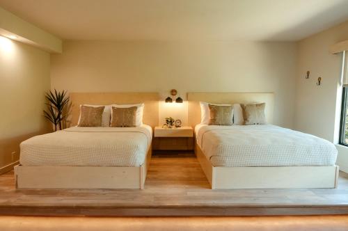 a bedroom with two beds and a window at Brut Hotel in Tulsa