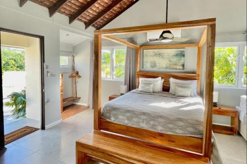 a bedroom with a wooden canopy bed in a villa at Luxury villa located in Montego Bay, Jamaica in Montego Bay