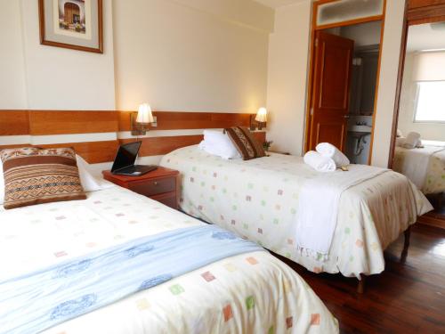 リマにあるSuite Service Apart Hotelのベッドが2つと鏡があるホテルの部屋