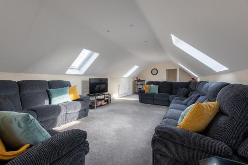 a living room with blue couches and a tv at Seaview Cottage in Cardiff