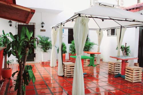 um pátio com um guarda-chuva, mesas e vasos de plantas em H B SULTAN SUITE em Cartagena de Indias