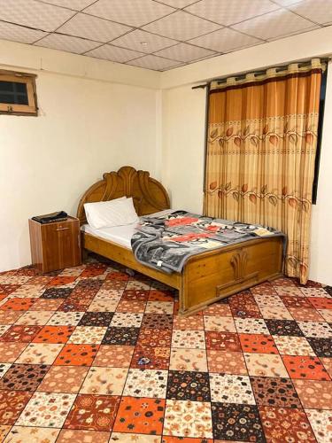 a bedroom with a bed and a checkered floor at Finger Peak Hotel in Kalām