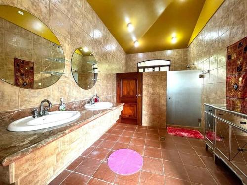 a large bathroom with two sinks and two mirrors at Lake Arenal Killer View Villa in Tilarán