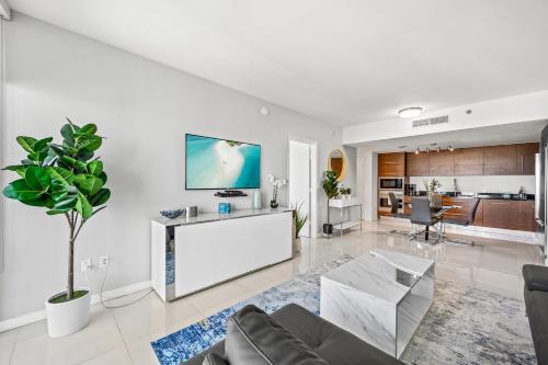 マイアミにある*ICONIC W ICON CONDO/ POOL&WATERVIEWS*FREESPA*のソファと壁掛けテレビのあるリビングルーム