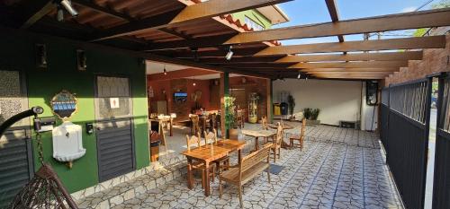 um pátio exterior com mesas e cadeiras e um restaurante em CASA DA ZEZÉ Pousada & Hotel ITABORAÍ em Itaboraí
