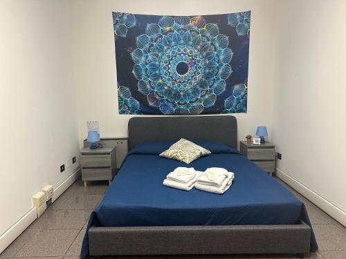 Un dormitorio con una cama azul con toallas. en My Room Zen Relax, en Reggio Emilia
