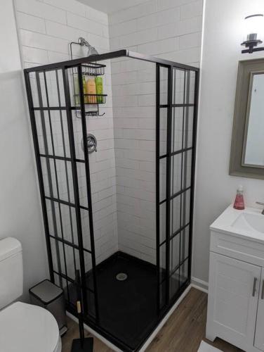 a shower with a black frame in a bathroom at Newly Renovated Studio - Close to WakeMed Raleigh in Raleigh