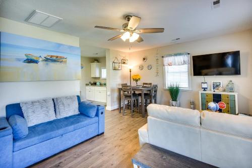 a living room with a blue couch and a ceiling fan at Hampton Home with Grill Less Than 1 Mi to Beach! in Hampton
