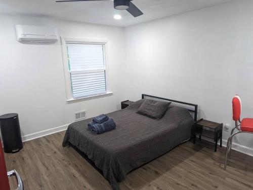 a bedroom with a bed and a window and a fan at Newly Renovated Studio - Close to WakeMed Raleigh in Raleigh