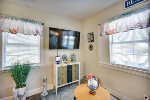 a living room with two windows and a flat screen tv at Hampton Home with Grill Less Than 1 Mi to Beach! in Hampton