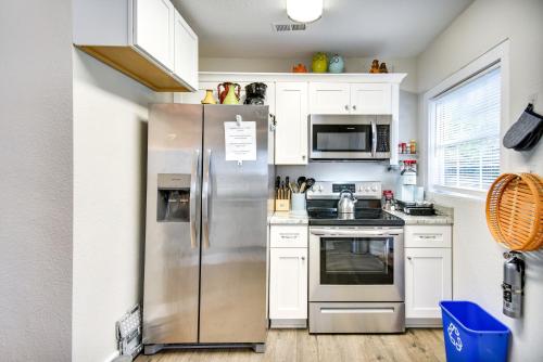 a kitchen with a stainless steel refrigerator and white cabinets at Hampton Home with Grill Less Than 1 Mi to Beach! in Hampton