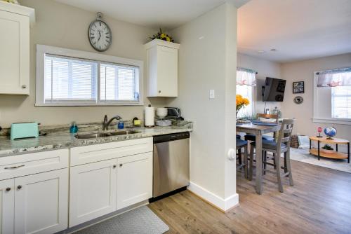 a kitchen with white cabinets and a table with a clock at Hampton Home with Grill Less Than 1 Mi to Beach! in Hampton