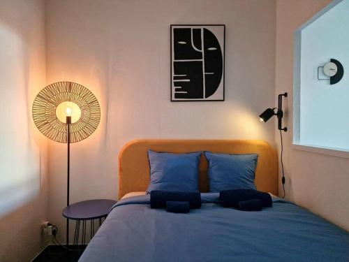 a bedroom with a blue bed and a lamp at Hakuna Matata @ Opera in Antwerp