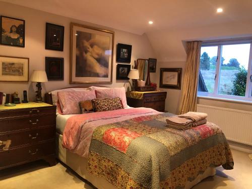 een slaapkamer met een bed, een dressoir en een raam bij A magical countryside retreat in New Alresford