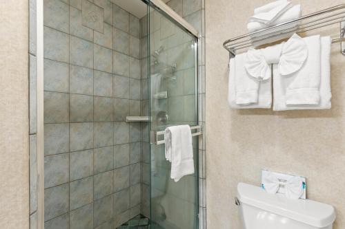 a bathroom with a shower and a toilet and towels at Beachcomber Motel in Fort Bragg