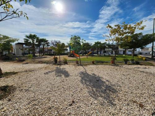 un parque con parque infantil con columpio en Palmeira71, acogedora Casa en Privada de ValleAlto, en Bellavista