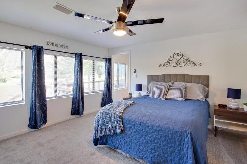 a bedroom with a blue bed with a ceiling fan at Modern Retreat Lake House @Lake Talquin in Tallahassee